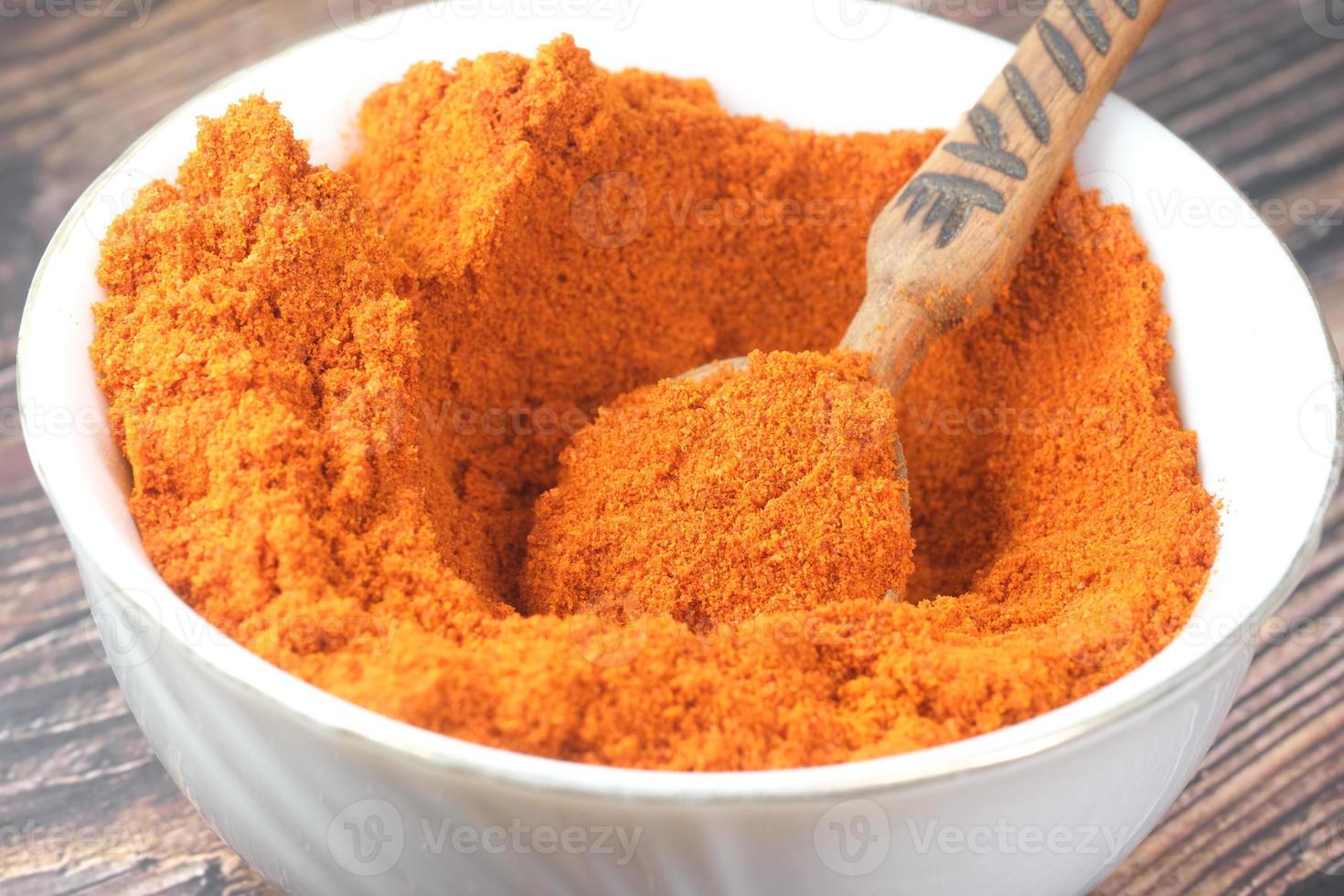 Chili powder and red peppers on table background. photo