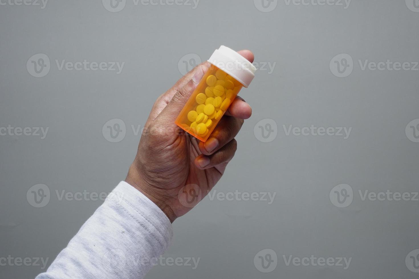 young man hand holding medicine pill container photo