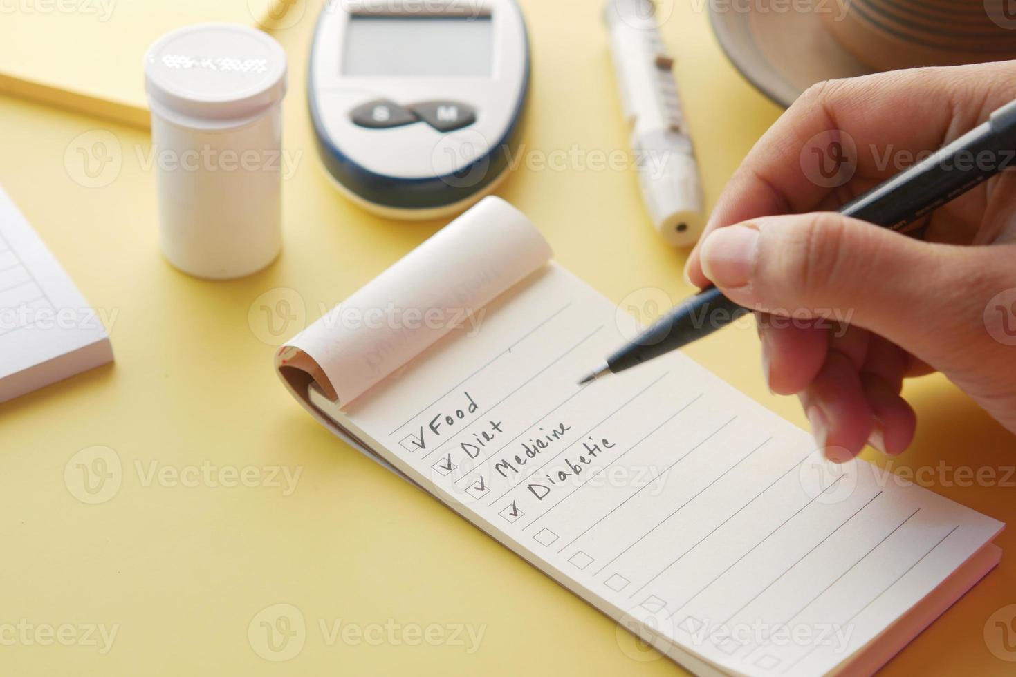 check mark on a check box on a paper with glucose meter on table photo