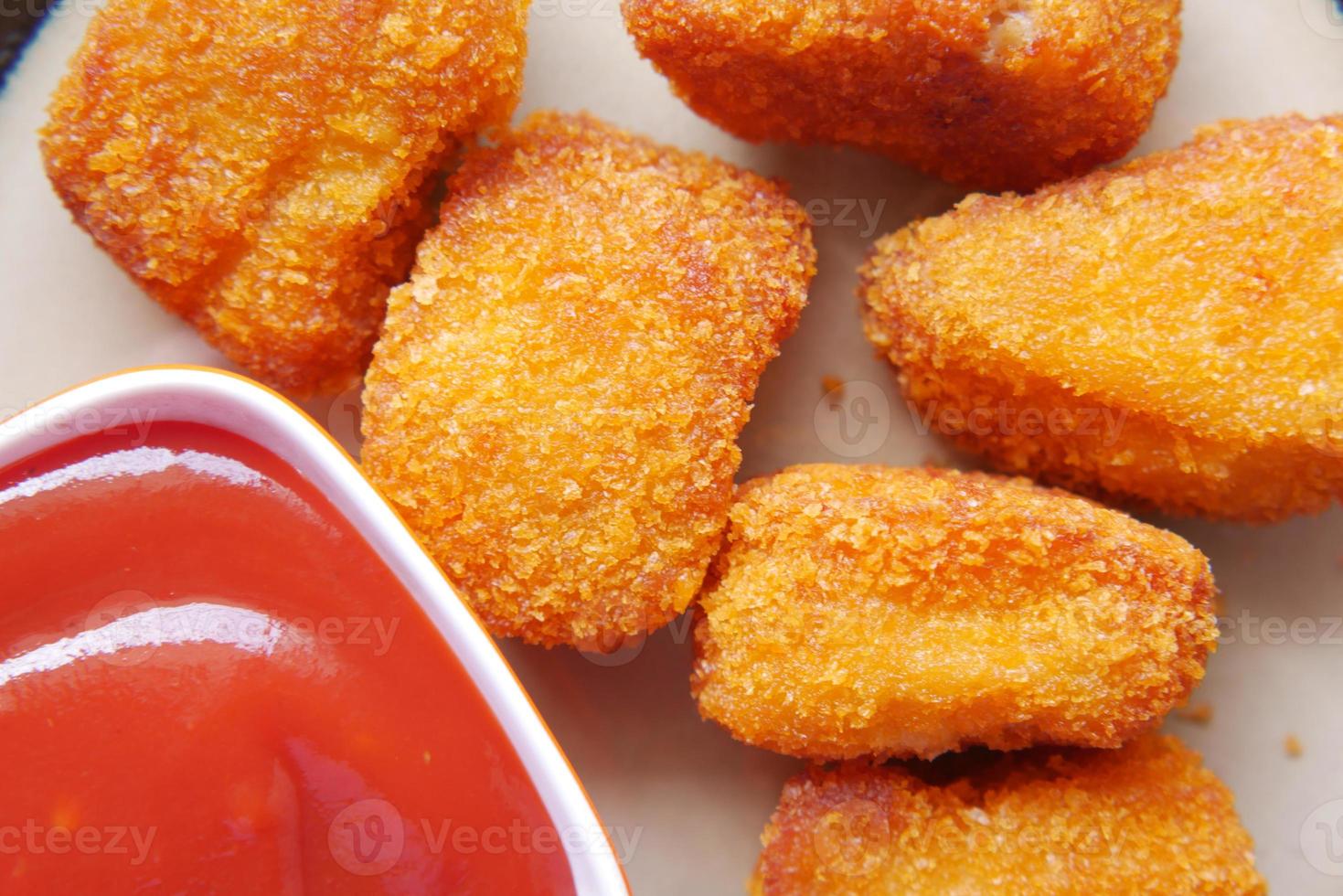 Cerca de nugget de pollo y salsa en la mesa foto