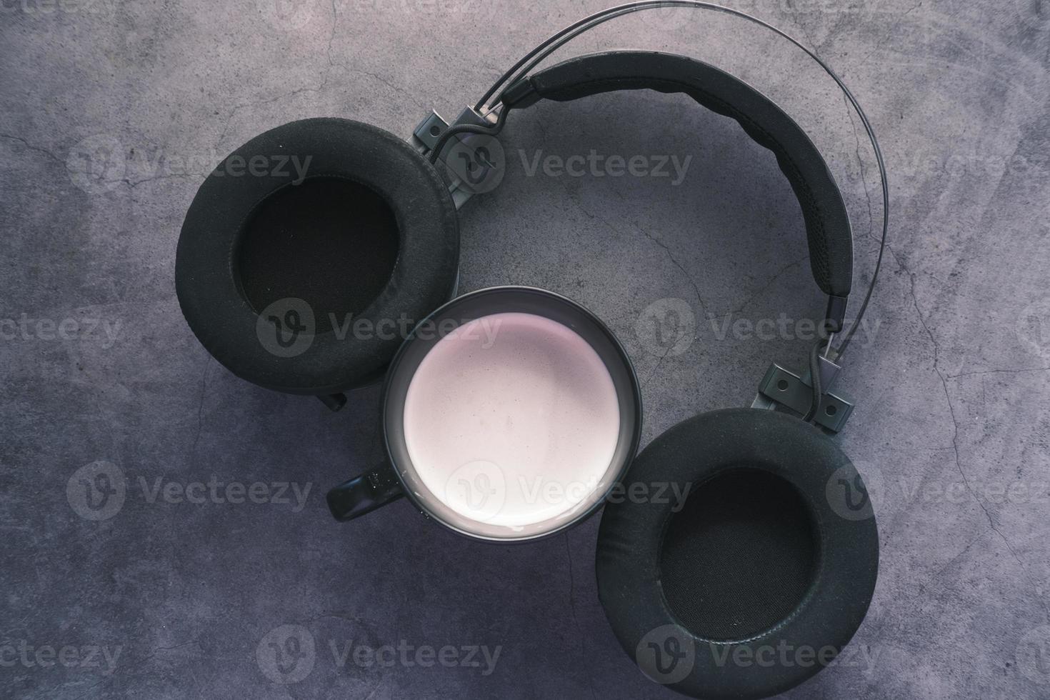 café y auriculares inalámbricos sobre fondo negro foto
