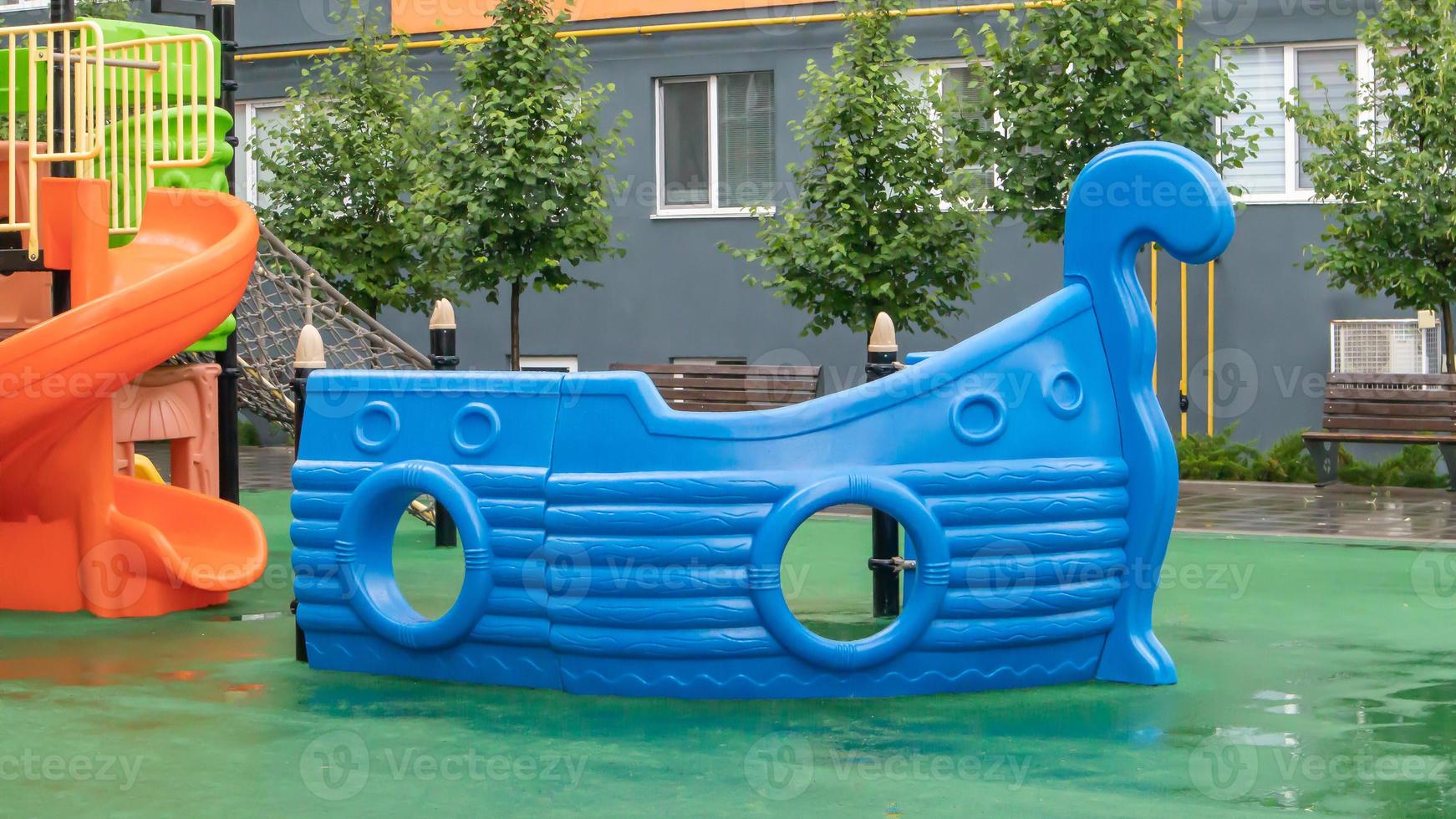 un patio de edificios de gran altura con un nuevo y moderno parque infantil colorido y grande en un día lluvioso de verano sin gente. patio de juegos al aire libre vacío. un lugar para juegos y deportes infantiles. foto