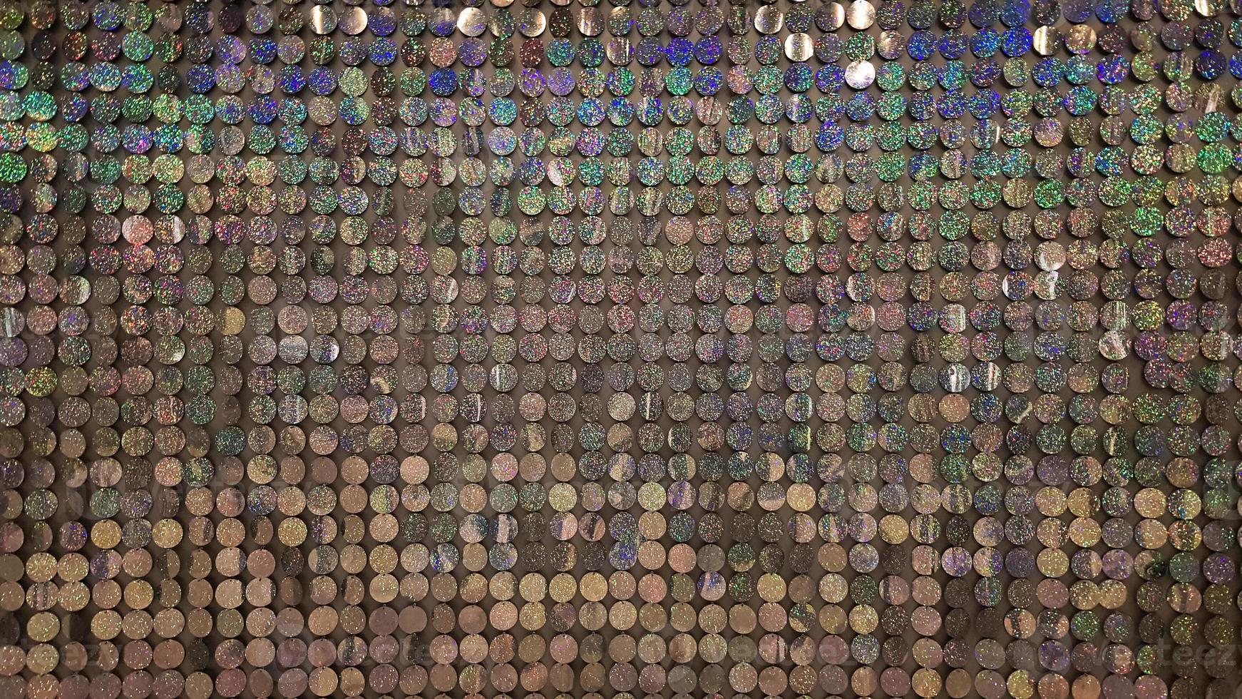 Macro close up of sparkles. Abstract background with gray sparkles. Texture scales of round spangles with color transition. Sequin background. Template for design. Festive background. photo
