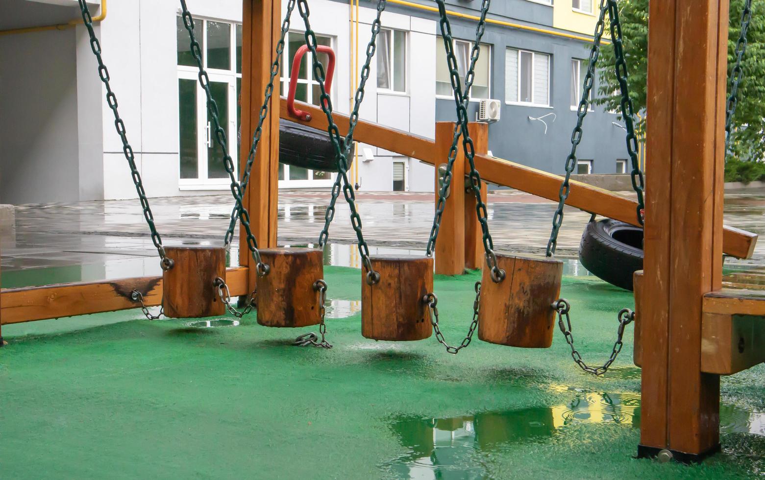 The courtyard of a high-rise building with a modern large playground made of wood and plastic on a rainy summer day without people. Ukraine, Kiev - August 19, 2021. photo