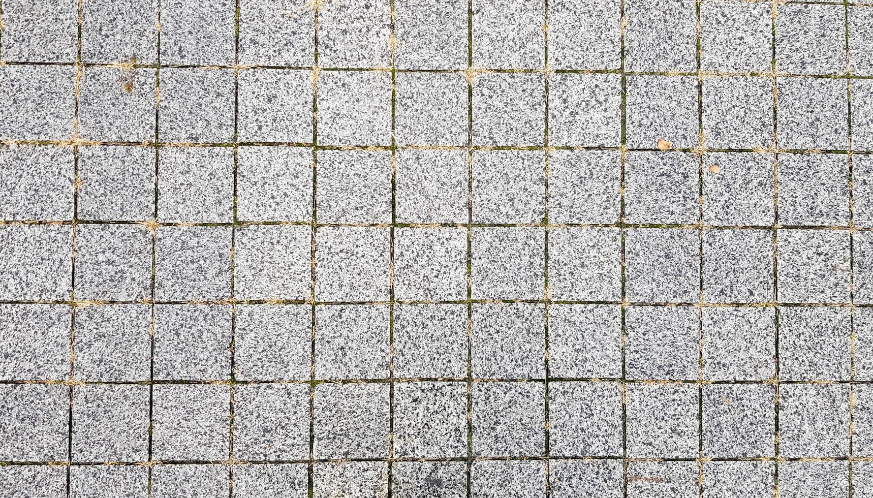 Stone sidewalk. Paving stones on roads and sidewalks in the old part of the city. Paving stone material background. Granite, cobblestone. Concrete paver floor template for background. photo