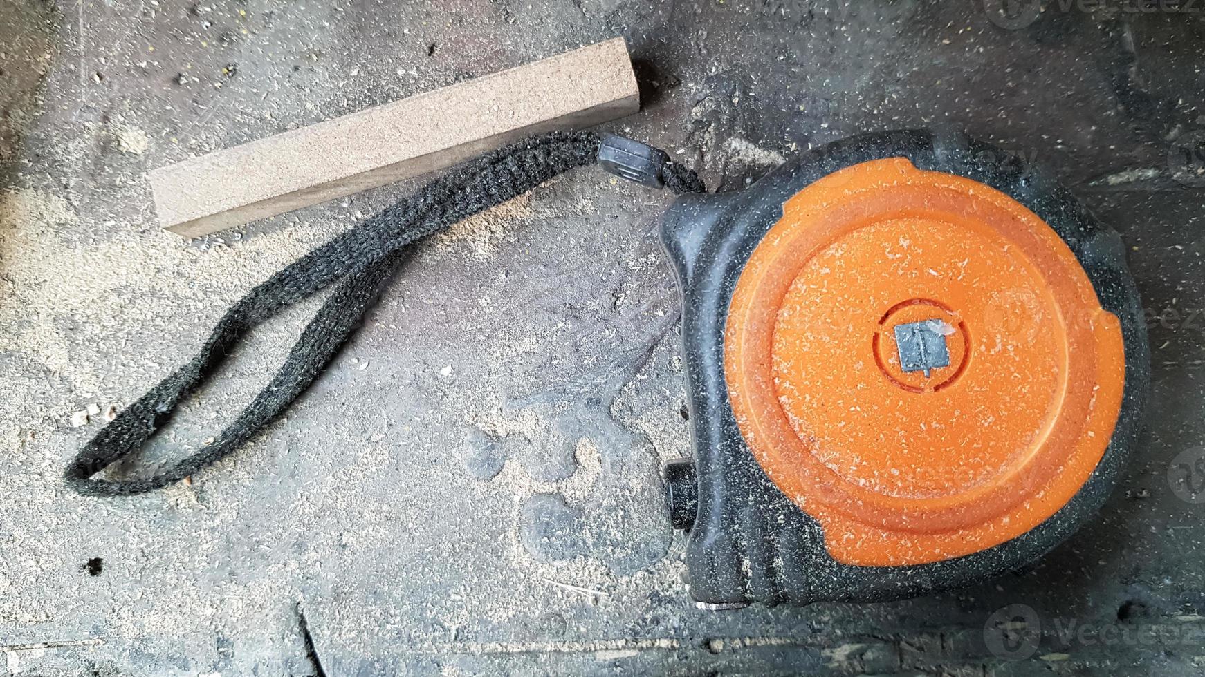 Instrument measuring tape under a layer of dust on a table in a workshop photo