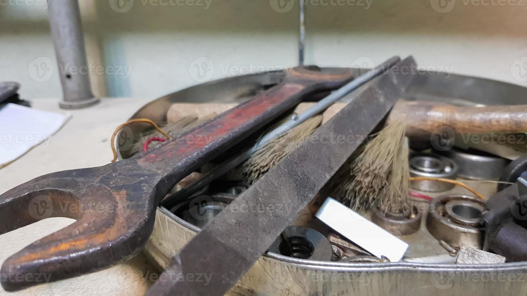 Work tools on the board and in the workshop. Workshop scene. A lot of old tools on a dirty desktop. The concept of carpentry and painting. photo
