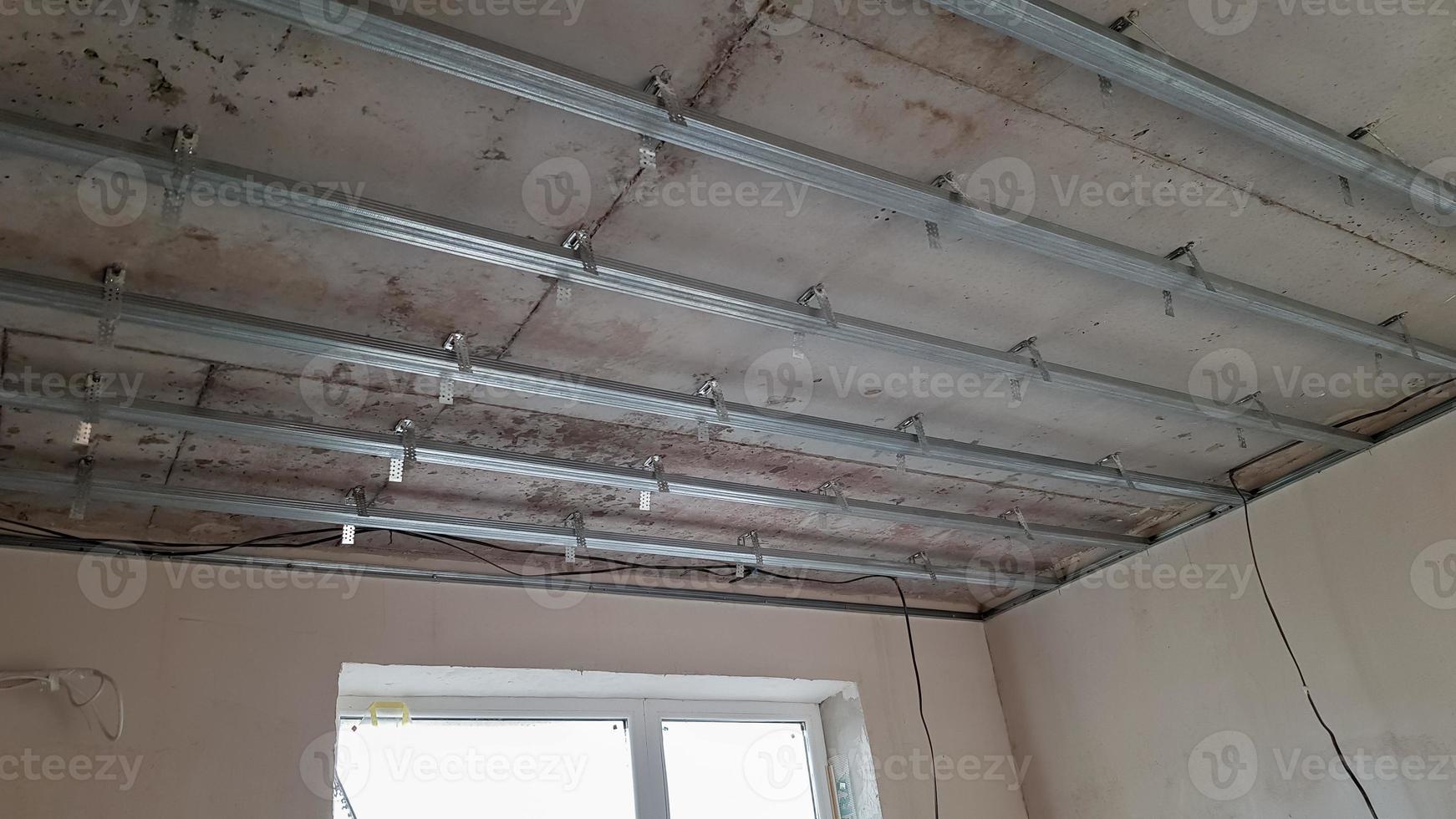False ceiling design, before installing drywall. Plasterboard ceiling of a house at a construction site, installation of a false ceiling in a square room photo