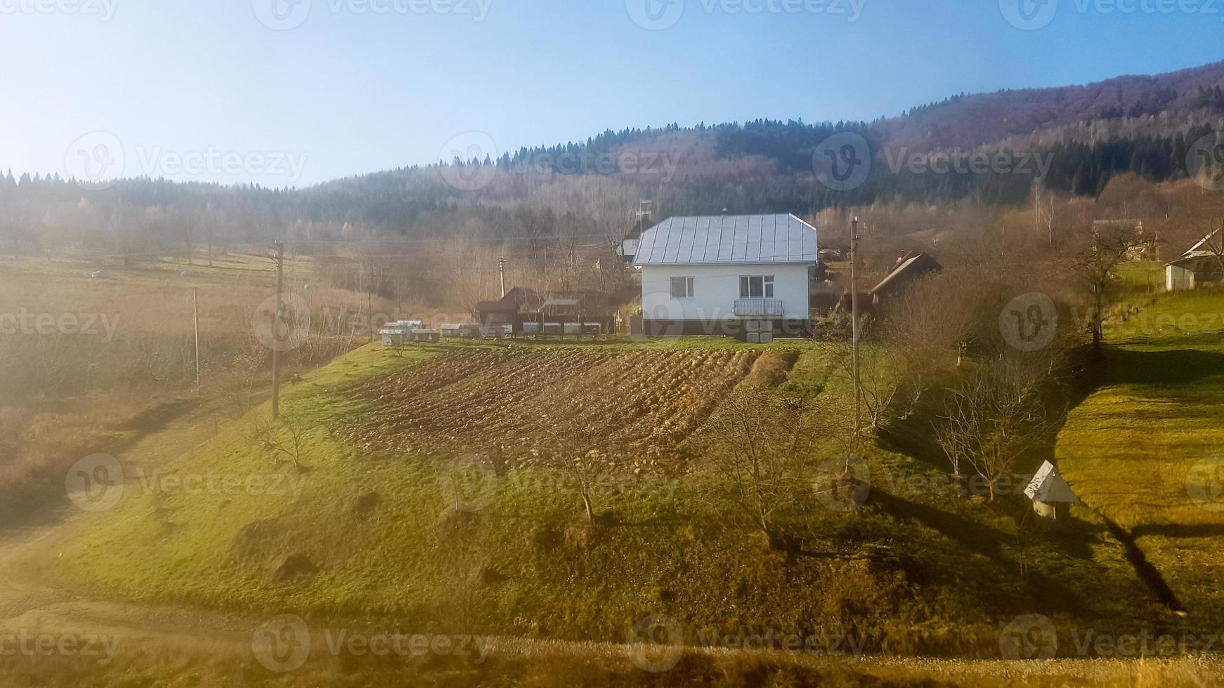 Landscape view of a mountain village in the Carpathians in the fall from the train window. A view from an old train of a mountain village photo