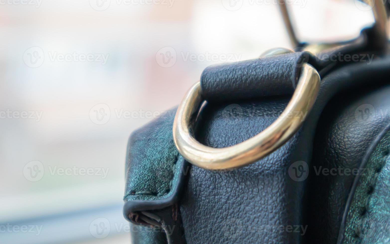 Metal gold loop oval ring attached to a leather bag. Selective focus. Part for a secure connection between two objects. Sewing accessories in the form of a ring for sewing bags, glossy. photo