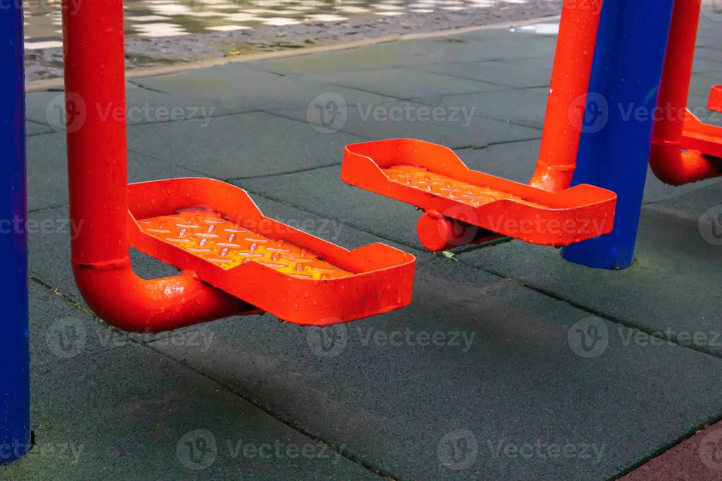 Exercise machines and fitness equipment for exercising on an open air sports ground in cloudy rainy weather without people. photo