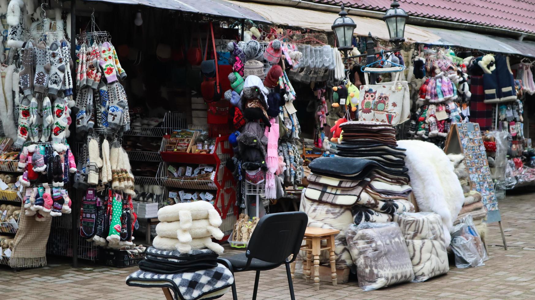 Souvenir market in Yaremche with traditional Carpathian handmade clothing, herbs and wooden tools. Ukrainian textiles, knitted socks, vests, hats. Ukraine, Yaremche - November 20, 2019 photo