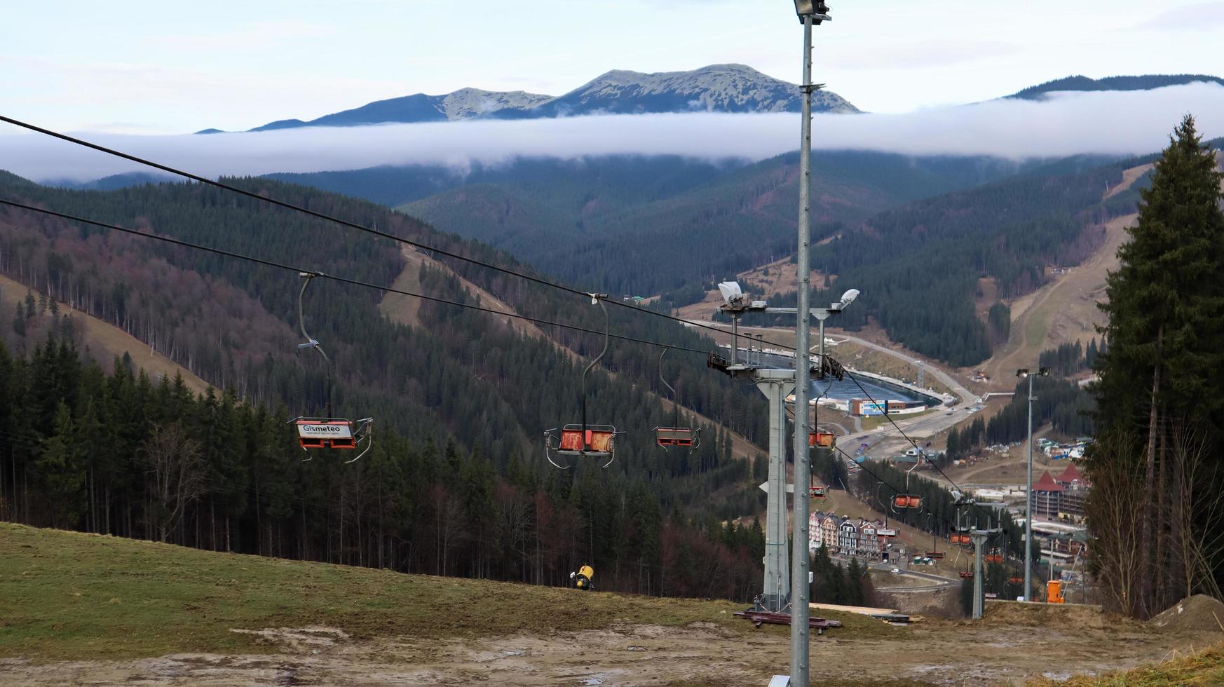 Ucrania, Bukovel - 20 de noviembre de 2019. Vista otoñal de la estación de esquí con un telesilla en el contexto de las pistas de montaña otoñales y la infraestructura en construcción de una estación de esquí de invierno. foto