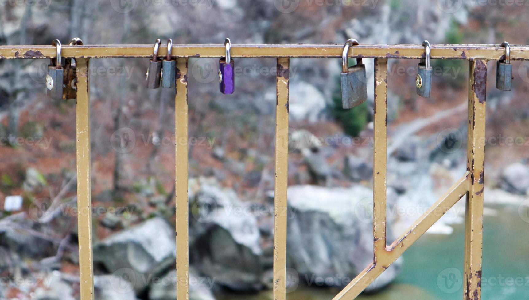 muchas cerraduras diferentes colgando de la cerca. la cerradura cerrada en el puente - tradición nupcial foto