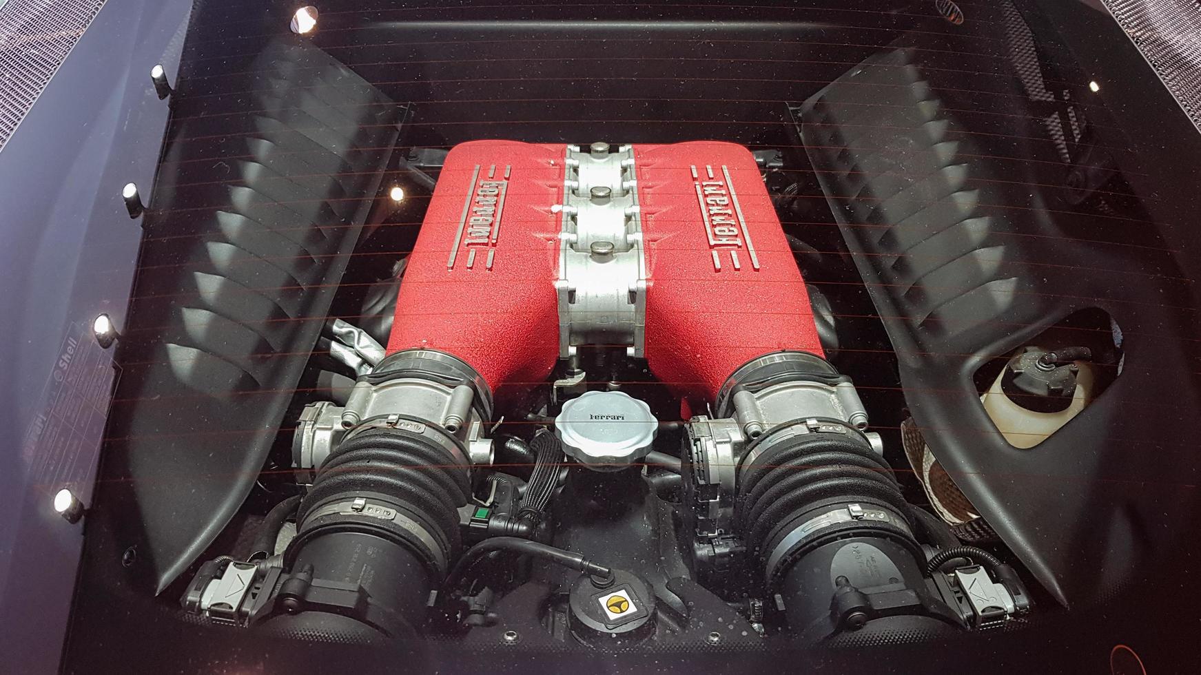A red Ferrari engine is parked in TNP's car, Rama 9 Road. A close-up of the glass cover of a Ferrari engine in a car dealership. Top view of the engine compartment. Ukraine, Kiev - October 16, 2020. photo