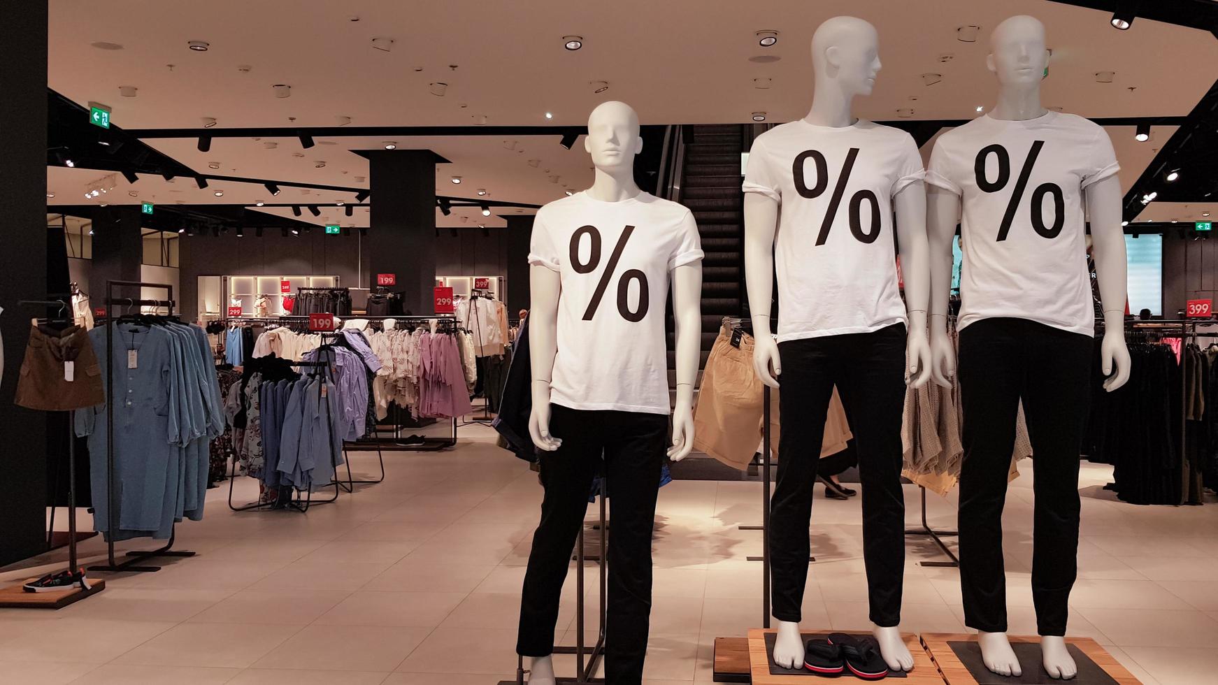 Mannequins wearing white T-shirts with a percent sale sign in a shopping mall Promotion, advertising, shopping and black friday concept. Ukraine, Kiev - September 1, 2020 photo