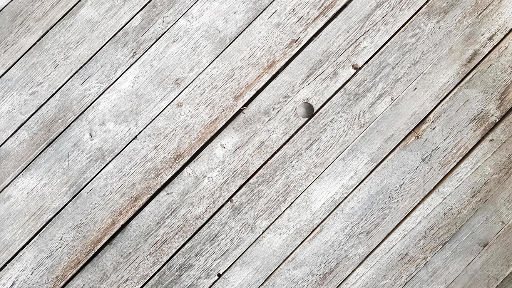 Gray wooden background with diagonal lines. Board background with copy space. Wooden old boards with cracked gray paint on the diagonal. Selective focus. Textured wooden background. photo