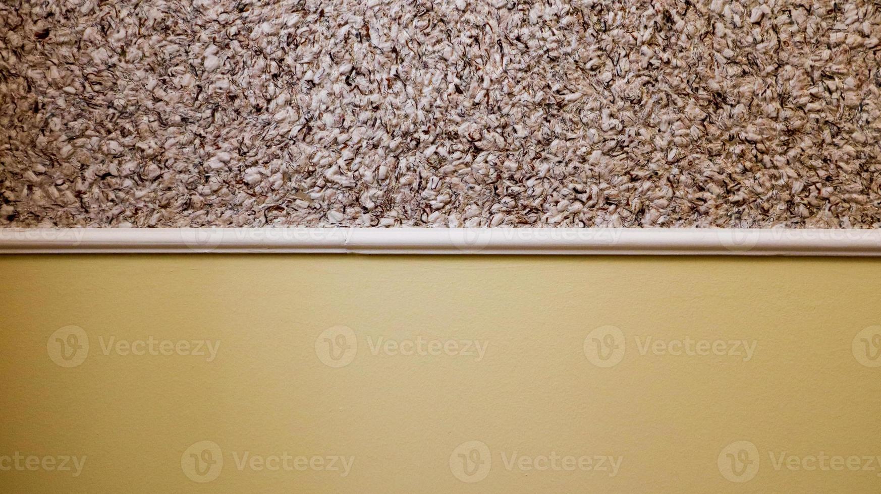 decorative plaster and semi-painted wall in beige. Textured background. Two color wall. The yellow and beige background is painted in two different colors. Abstract wallpaper. copy space photo
