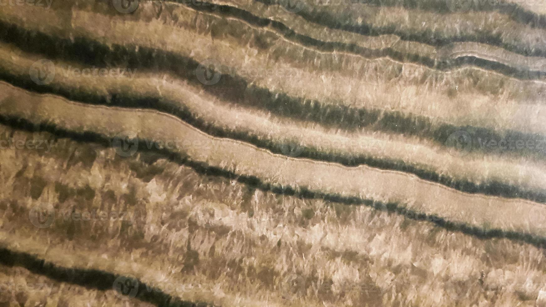 The surface of Sandstone with wavy brown veins. Sulphide agate texture. Wide image of brown natural stone texture Sphalerite. Beautiful wavy pattern of cut of Schalenblende stone close-up photo