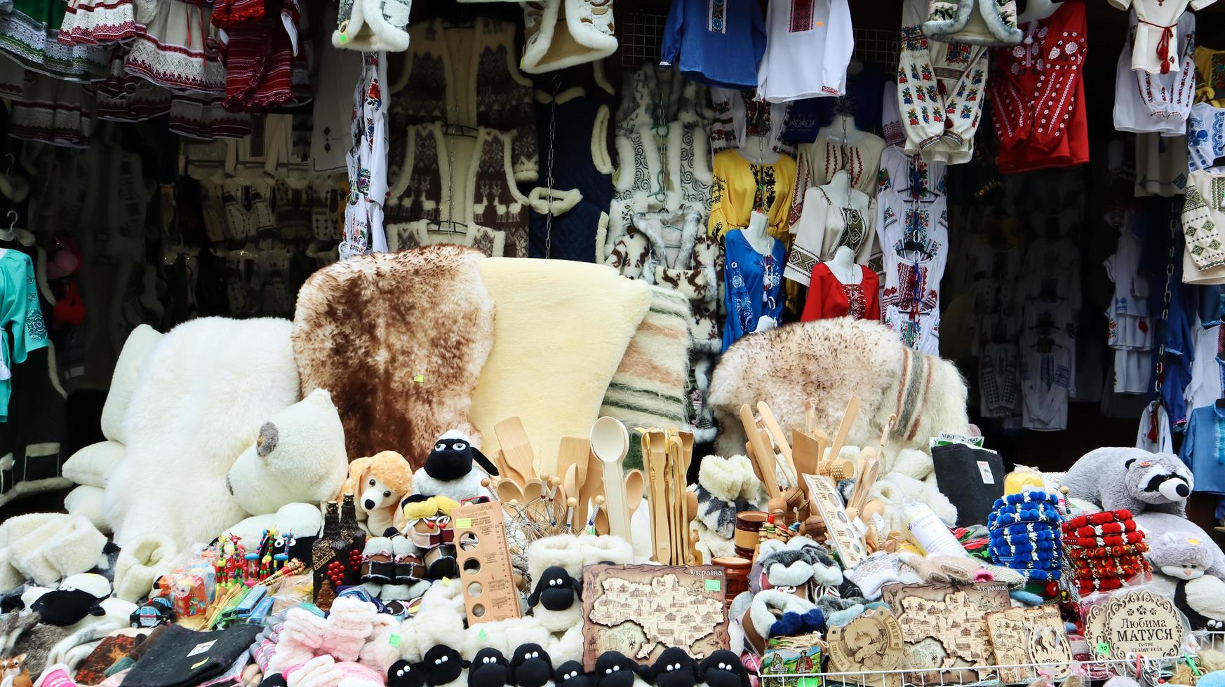 Souvenir market in Yaremche with traditional Carpathian handmade clothing, herbs and wooden tools. Ukrainian textiles, knitted socks, vests, hats. Ukraine, Yaremche - November 20, 2019 photo