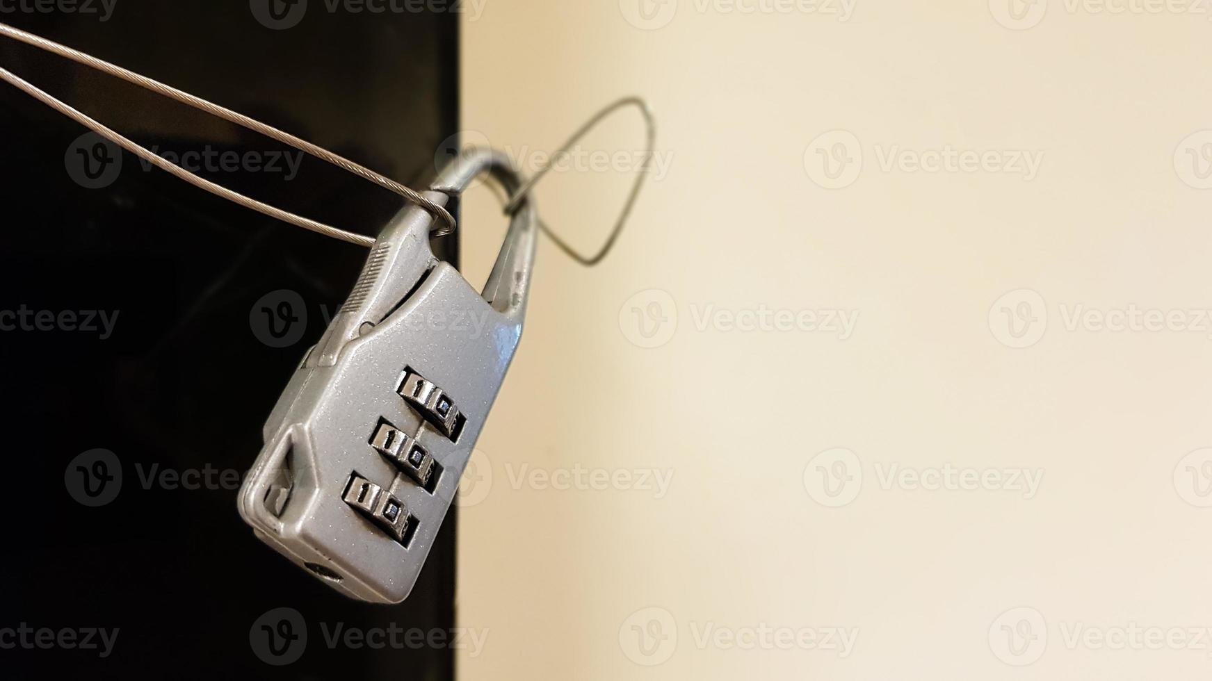 Close-up small combination lock closes electrical panel with black glass cover in office building corridor photo