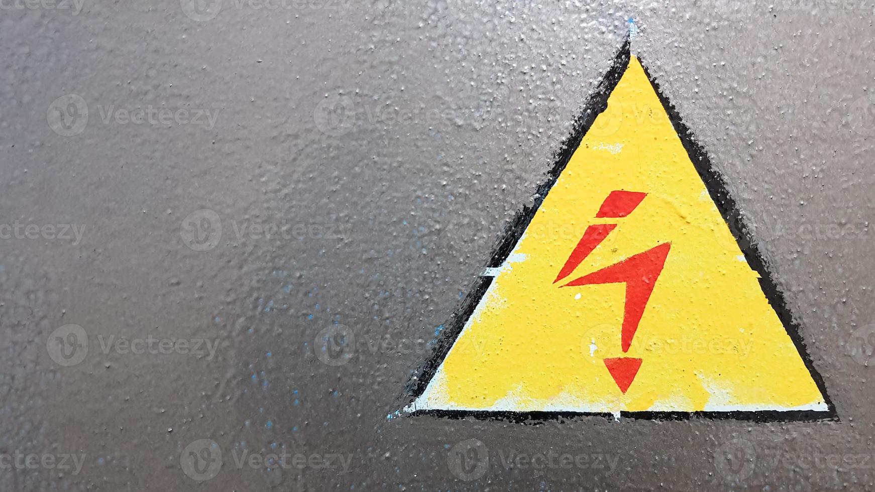 señal de seguridad amarillo y rojo sobre un fondo de metal plateado. relámpago de alto voltaje en un triángulo precaución precaución peligro electricidad muerte. foto