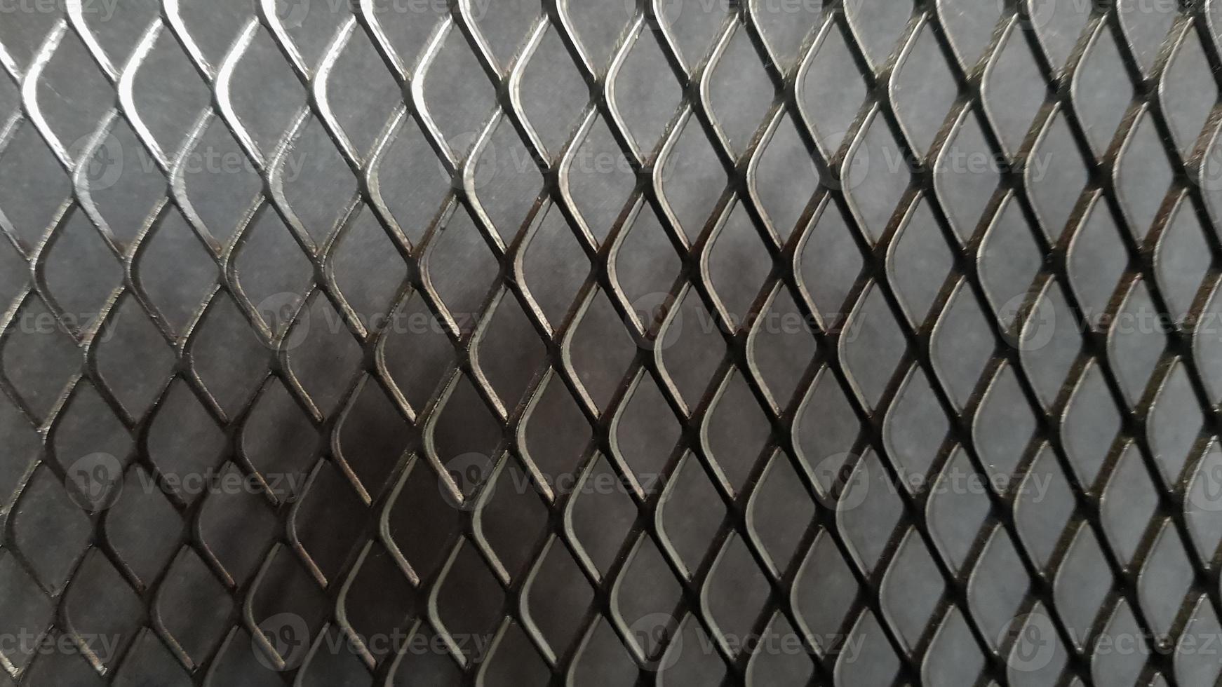 Metal mesh seamless pattern. Black metal mesh texture on a black background. Bulletin board for text and message design. Rhombus shape photo