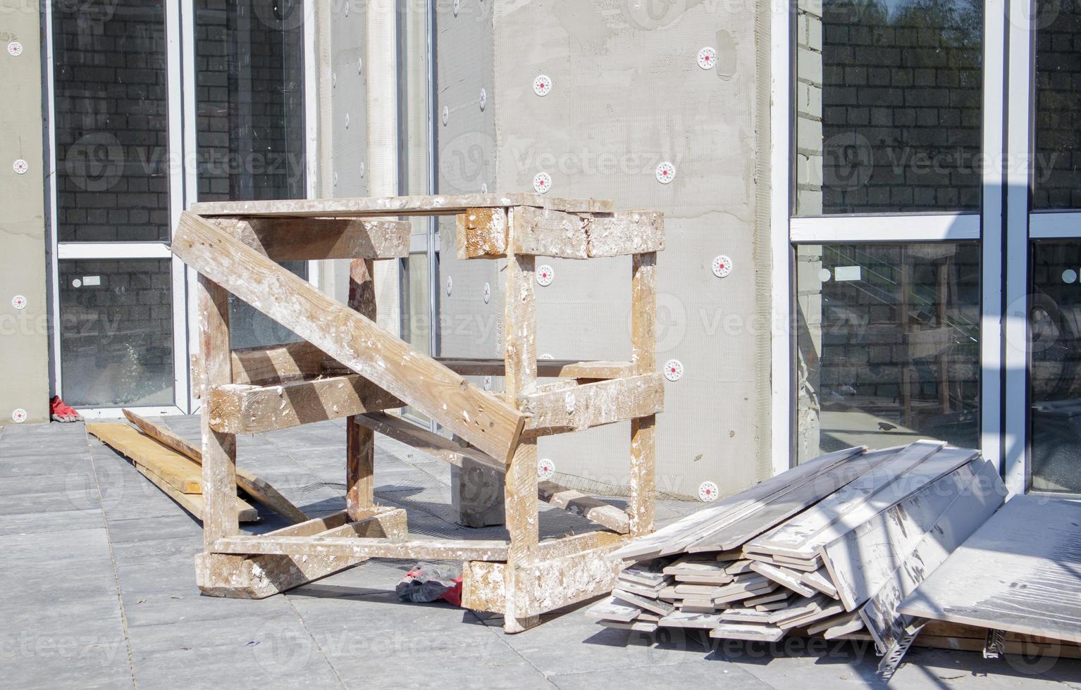 External thermal insulation of the building at the construction site with expanded polystyrene sheets. The process of work and the equipped workplace of the builder with materials and tools. photo