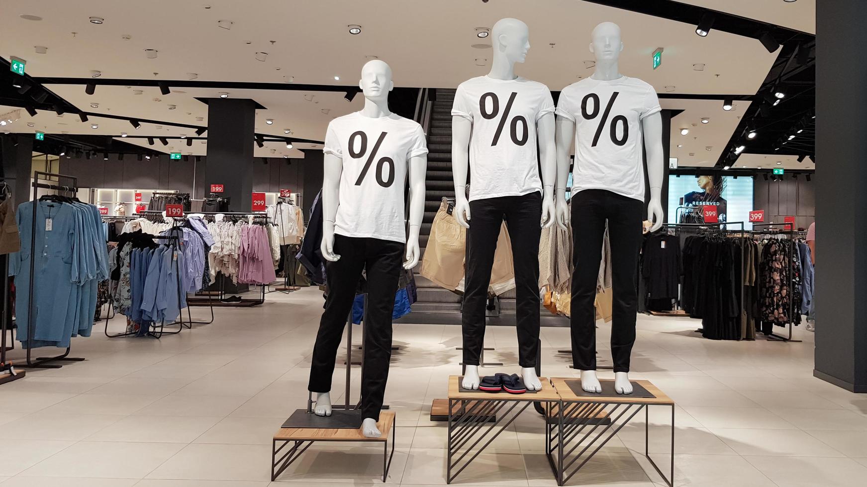 Mannequins wearing white T-shirts with a percent sale sign in a shopping mall Promotion, advertising, shopping and black friday concept. Ukraine, Kiev - September 1, 2020 photo