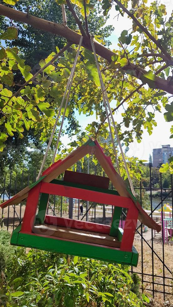 Handmade bird feeders made of wood in a city park. Bird house. photo