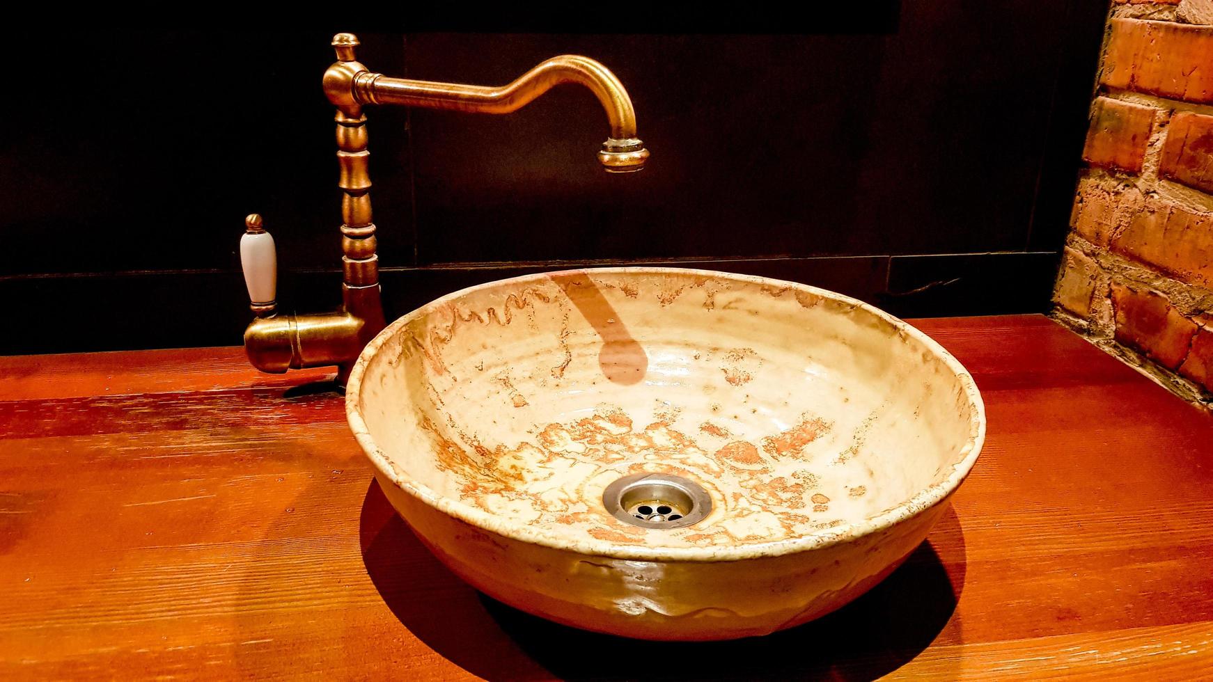 Vintage Beautiful faucet and golden mixer tap on a marble round sink in the bathroom. Interior of an expensive toilet with a marble sink photo