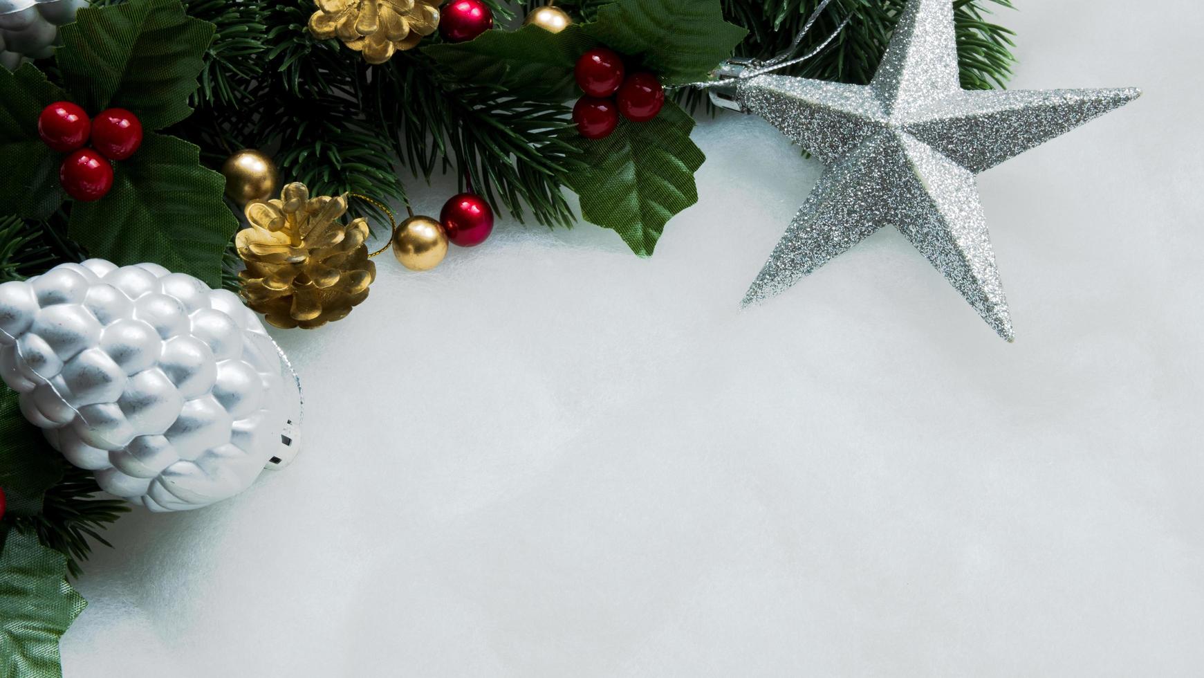 Adornos navideños, hojas de pino, bolas, bayas sobre fondo blanco como la nieve, concepto de Navidad foto