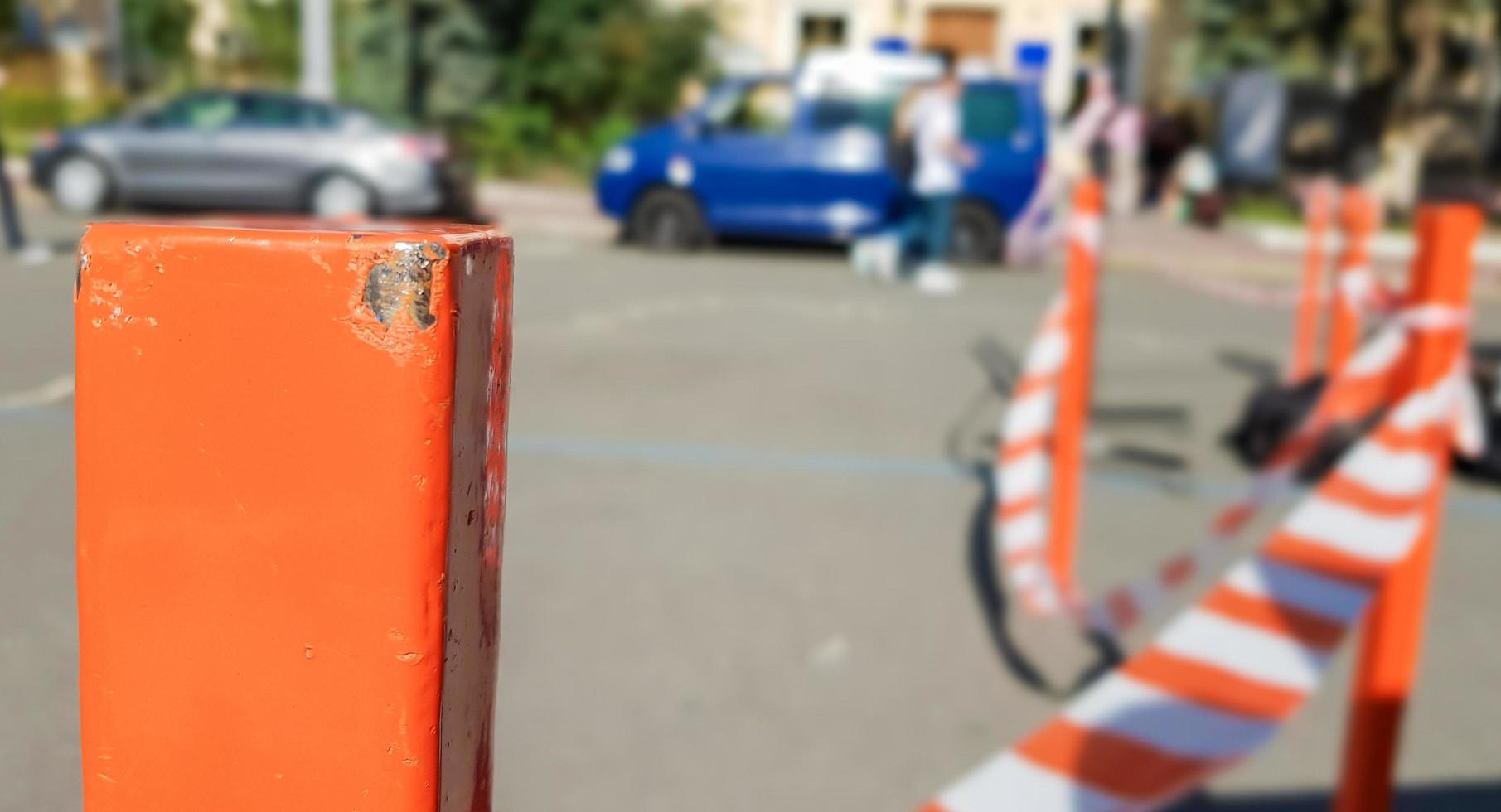 el blanco rojo no atraviesa la cinta y el poste de metal. Señal de cinta roja y blanca colgando de una valla metálica, peligro, advertencia. cinta y poste de metal rojo. La cinta prohibida encierra un área insegura. foto