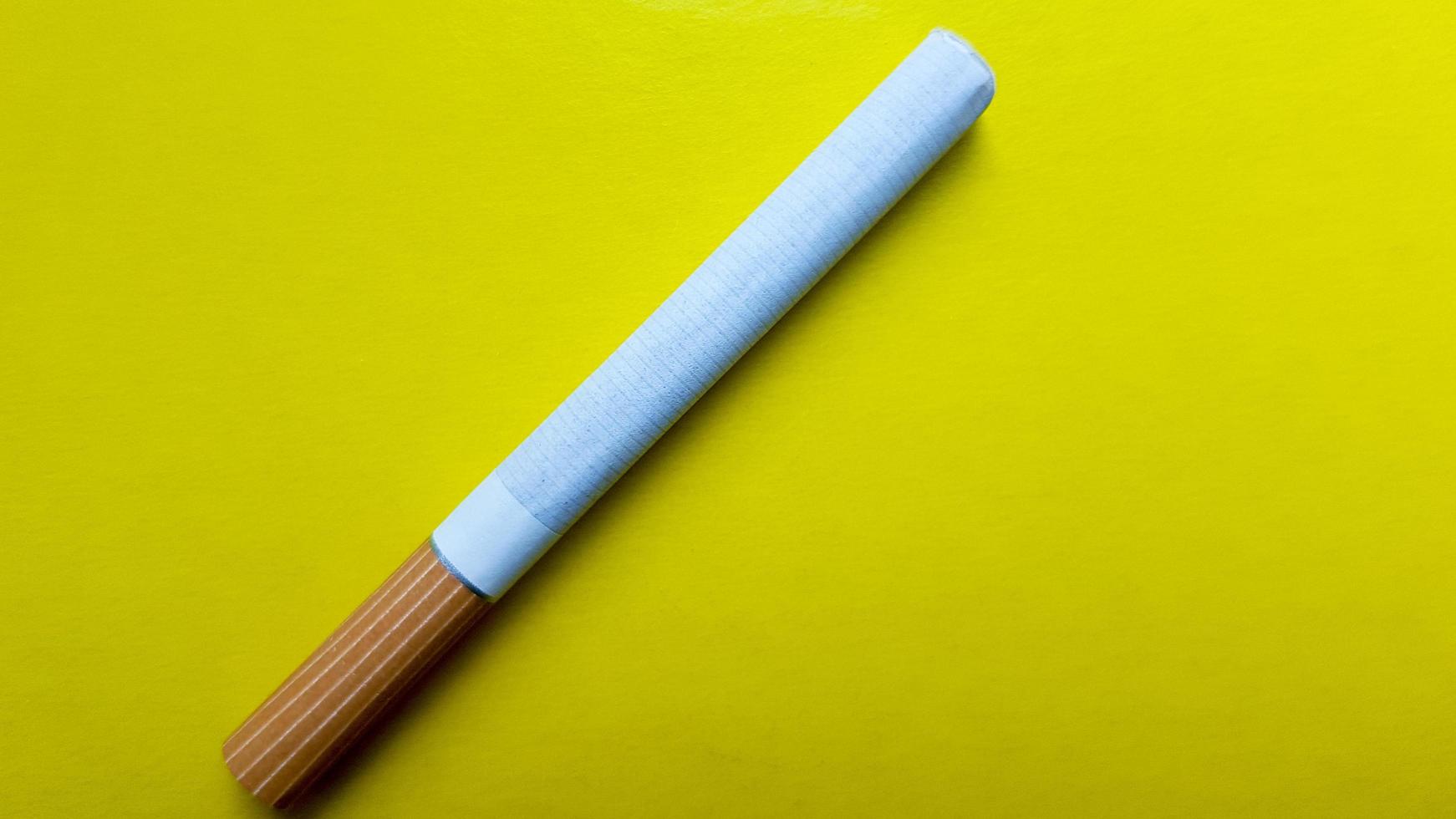 Cigarettes isolated diagonal on a yellow background photo