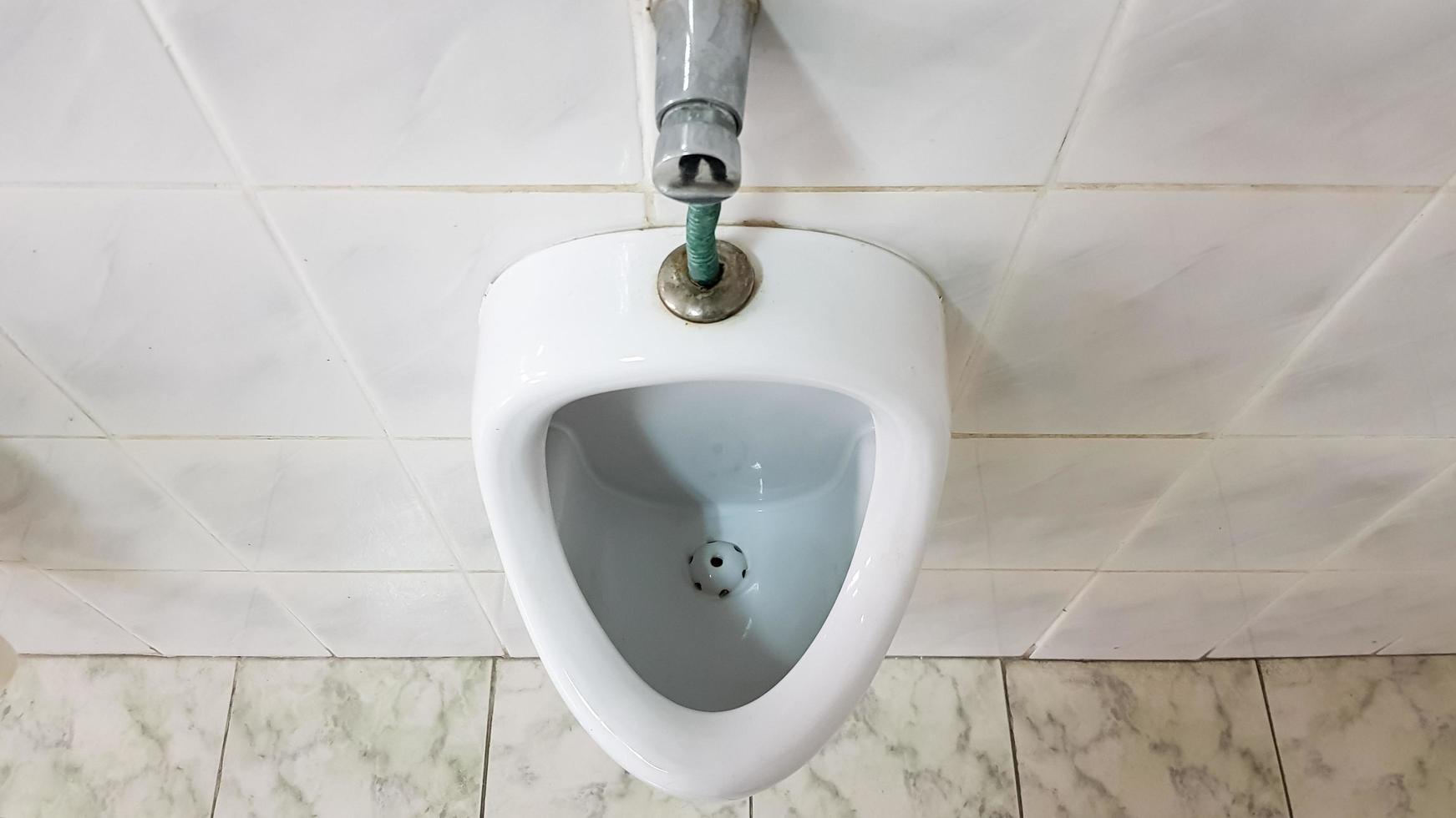 Public toilet with one ceramic urinal. Urinals prepare bowls for men. photo