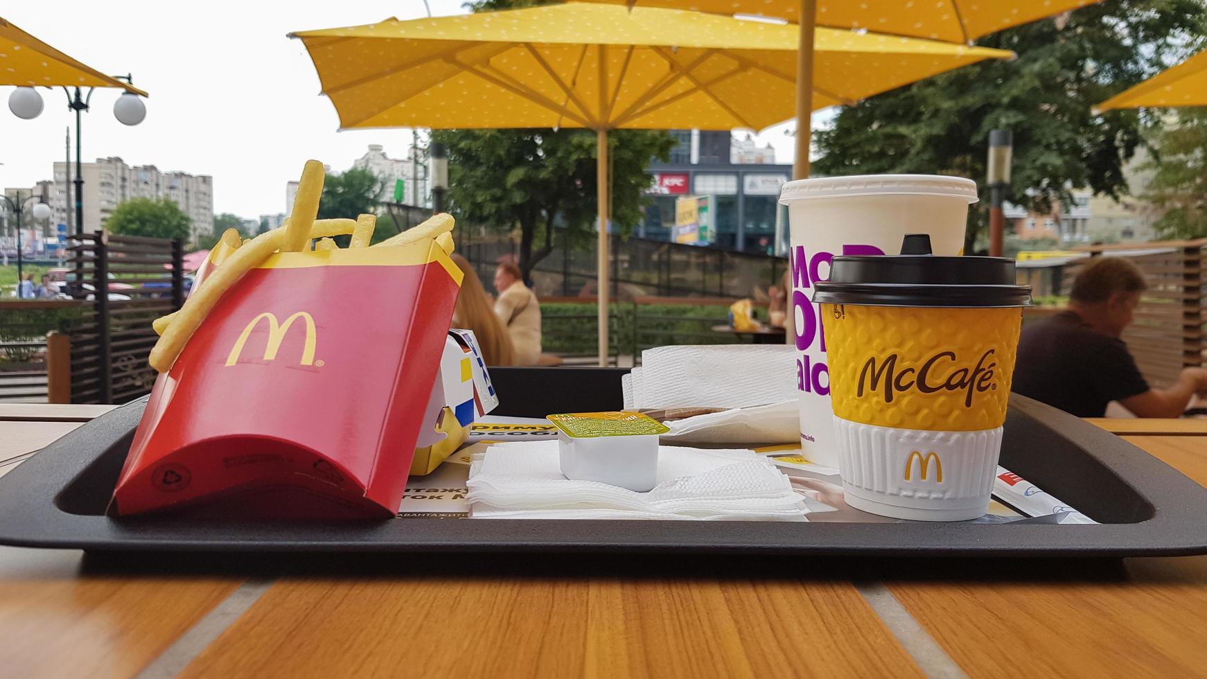 Hamburger, French fries, coffee and Coca Cola soft drink on the table in the McDonald's restaurant. Branches all over the world. Ukraine, Kiev - September 6, 2019. photo