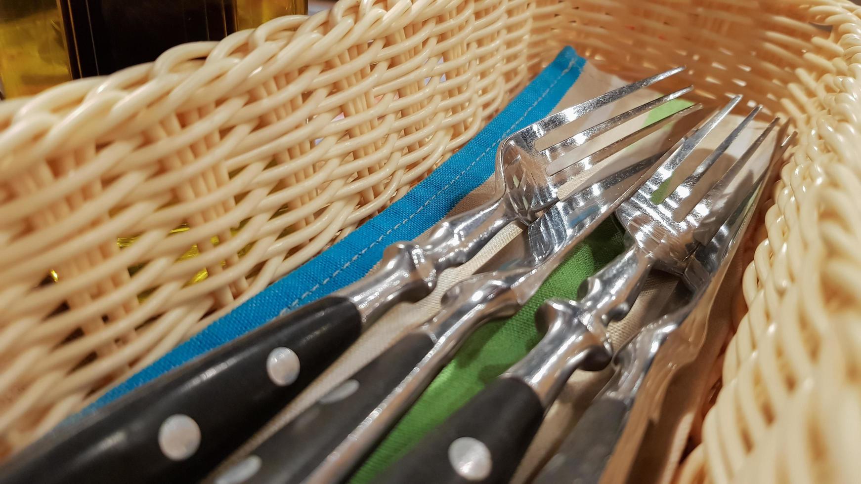 The served table in the restaurant. Fork, knife in a brown-yellow wicker pencil case. photo