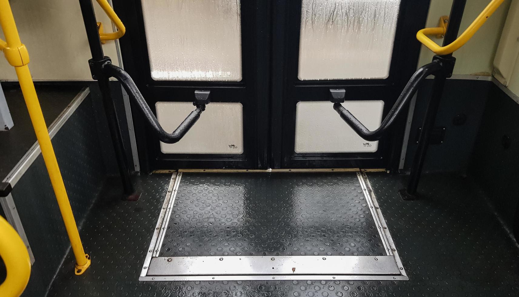 Bus door with yellow handles, interior view. The mechanism for opening and closing the doors of modern public transport in the city. photo