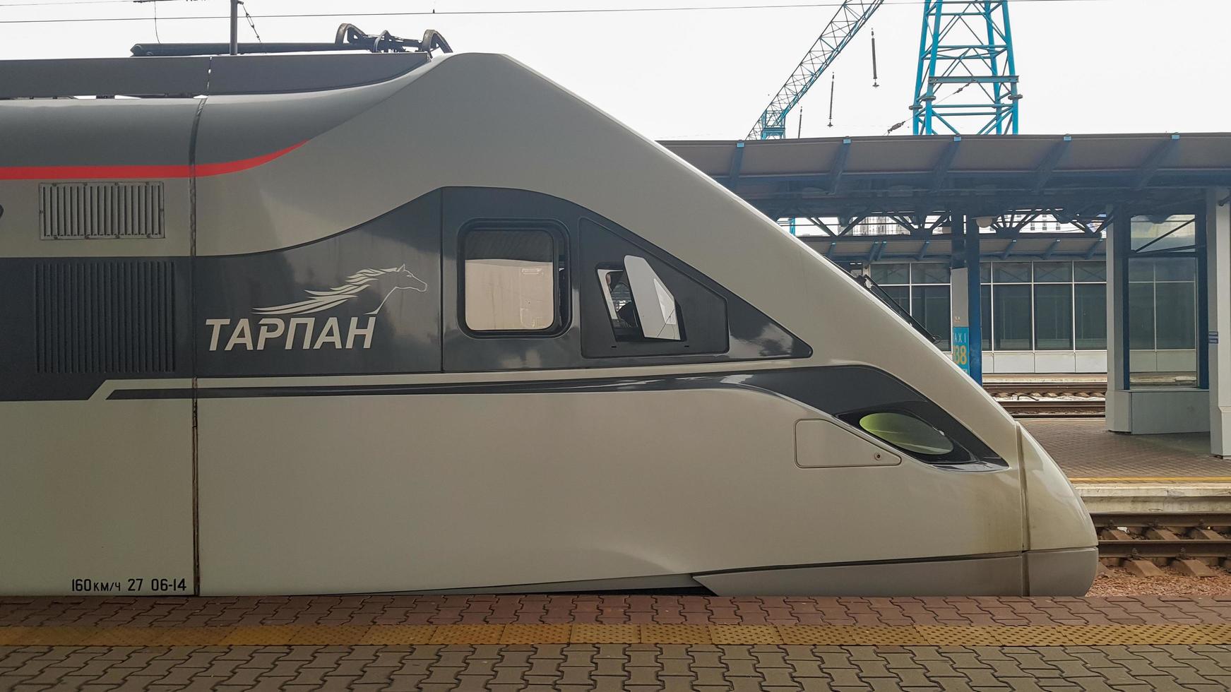 The high-speed passenger electric train Hyundai Rotem Tarpan HRCS2 Intercity stands on the platform of the central railway station in Kiev. Ukrainian railways. Ukraine, Kiev - June 09, 2021. photo