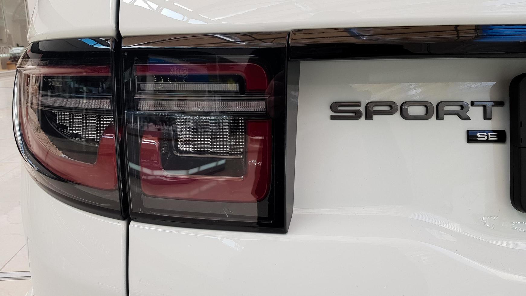 Ukraine, Kiev - March 27, 2020. Land Rover Discovery Sport shiny modern white car at the exhibition. Body, headlights close-up, rear and front view, chrome grille, car logo. photo