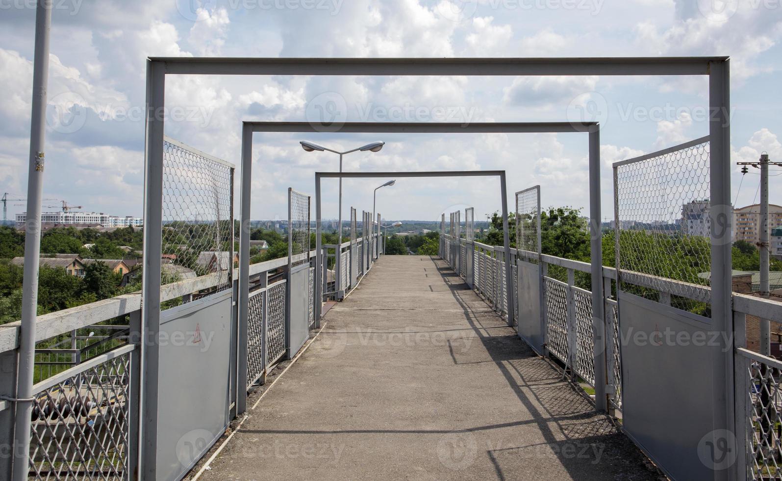 Railway bridge with steps, with impressive steps in perspective. Overhead pedestrian crossing. Bridge stairs connecting one platform to another at the train station. photo