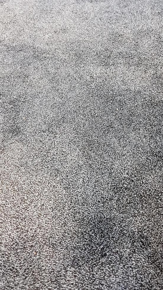 Gray carpet polyester texture. Seamless monochrome gray carpet texture background from above. Close-up. Vertical photography. photo