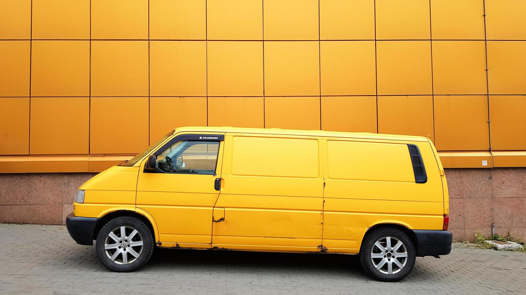 Ukraine, Kiev - March 27, 2020. Yellow Transporter in yellow on a background of a yellow building. photo