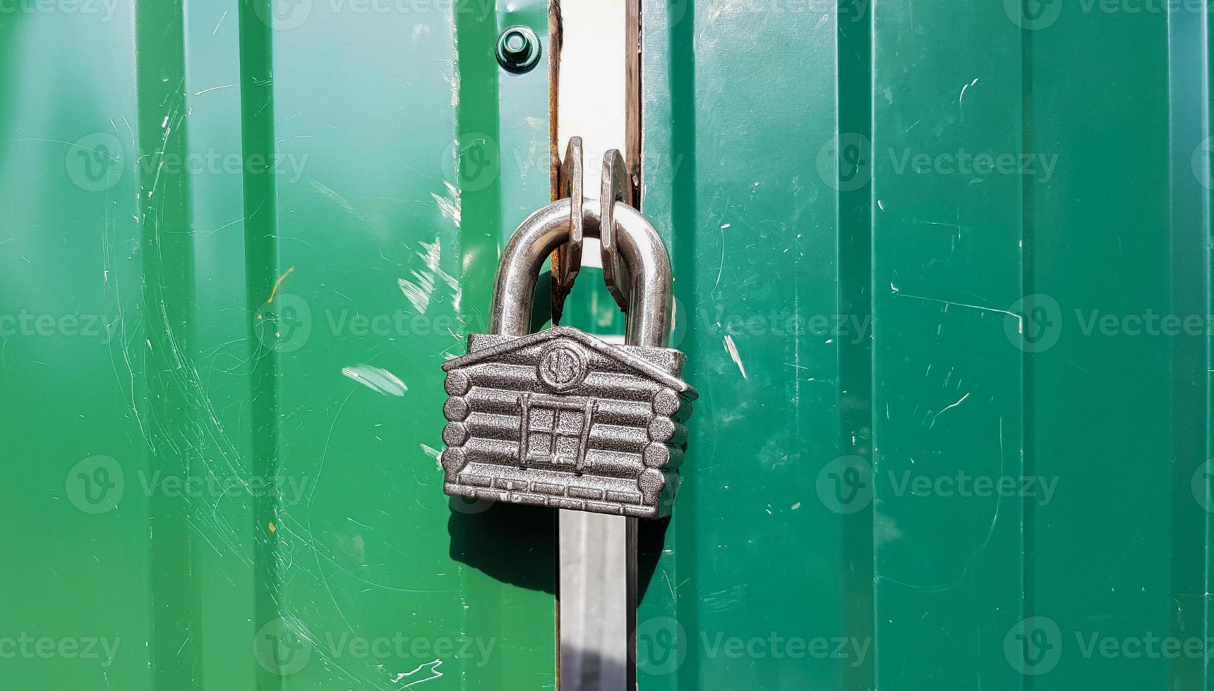 metal door with lock, texture and background. Background texture of an iron padlock on a rusty metal gate. photo