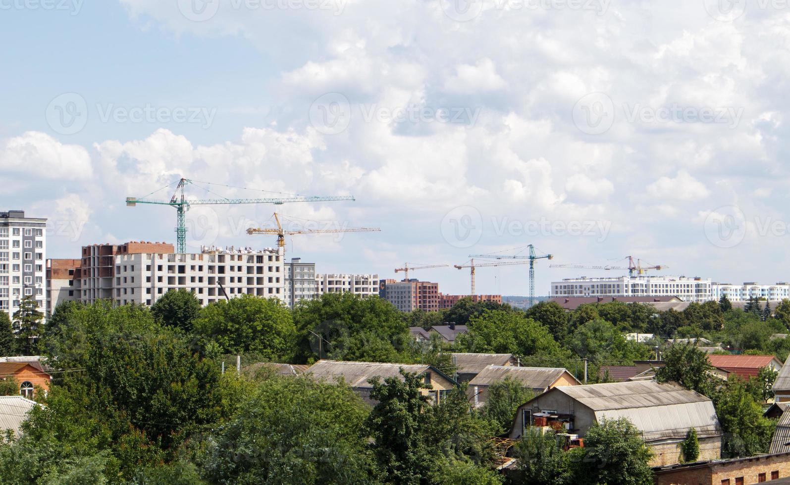 Skyline with new skyscrapers under construction. View of the cityscape with multi-storey residential buildings, houses under construction. photo