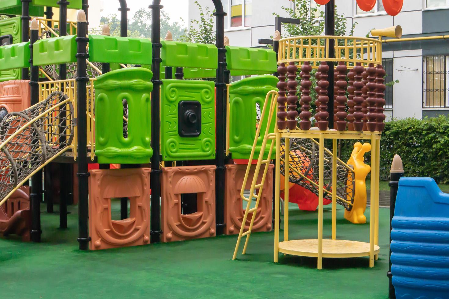 The courtyard of a high-rise building with a modern large playground made of wood and plastic on a rainy summer day without people. Ukraine, Kiev - August 19, 2021. photo