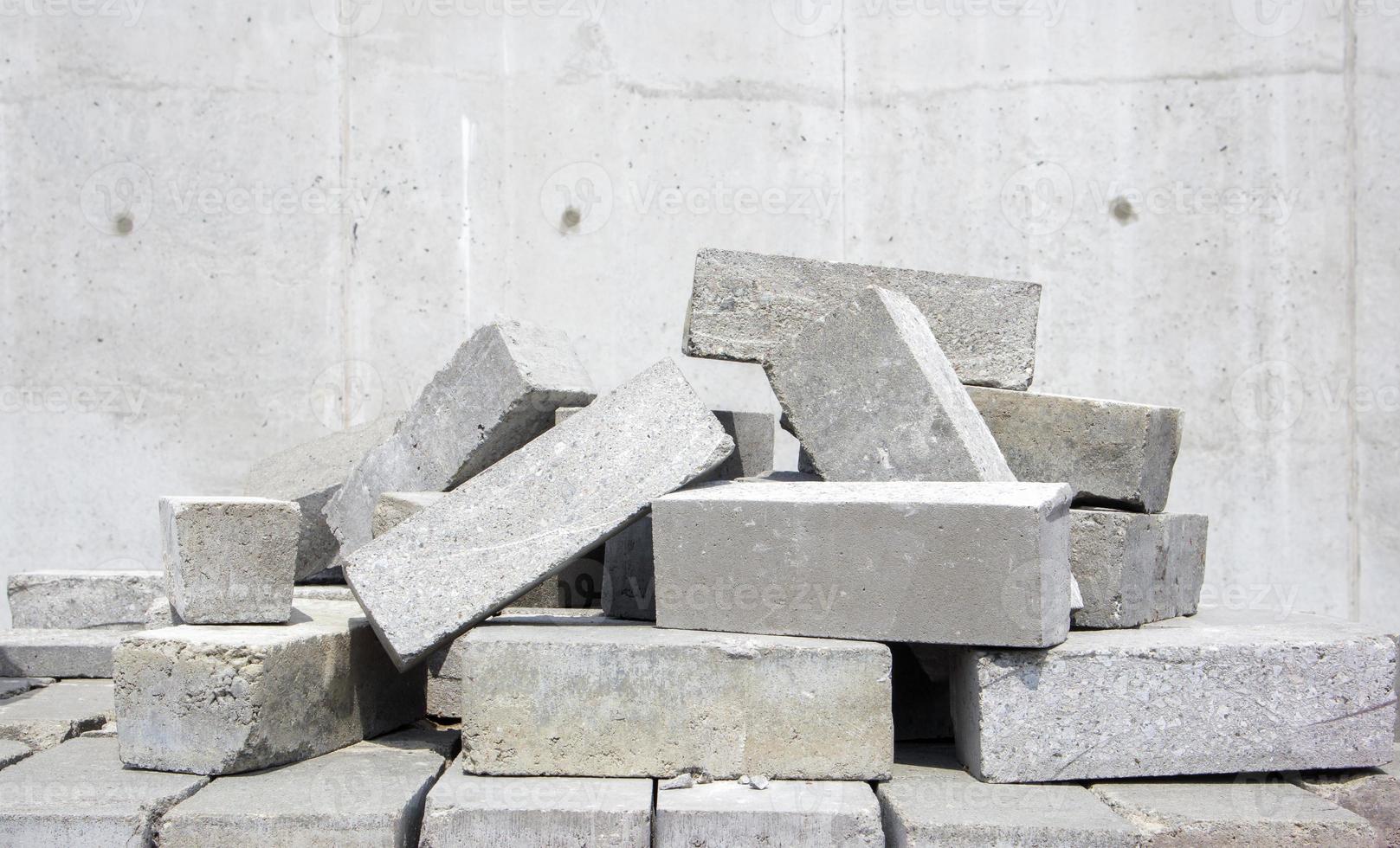 A pile of cement type bricks. Solid brick is used for construction. Lots of loose concrete bricks at the construction site. photo