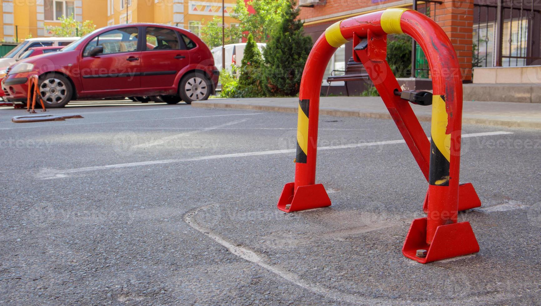 Manual parking barrier in red with a lock. Parking lock device. Parking barrier installed. A collapsible barrier prevents the vehicle from stopping at this point. photo