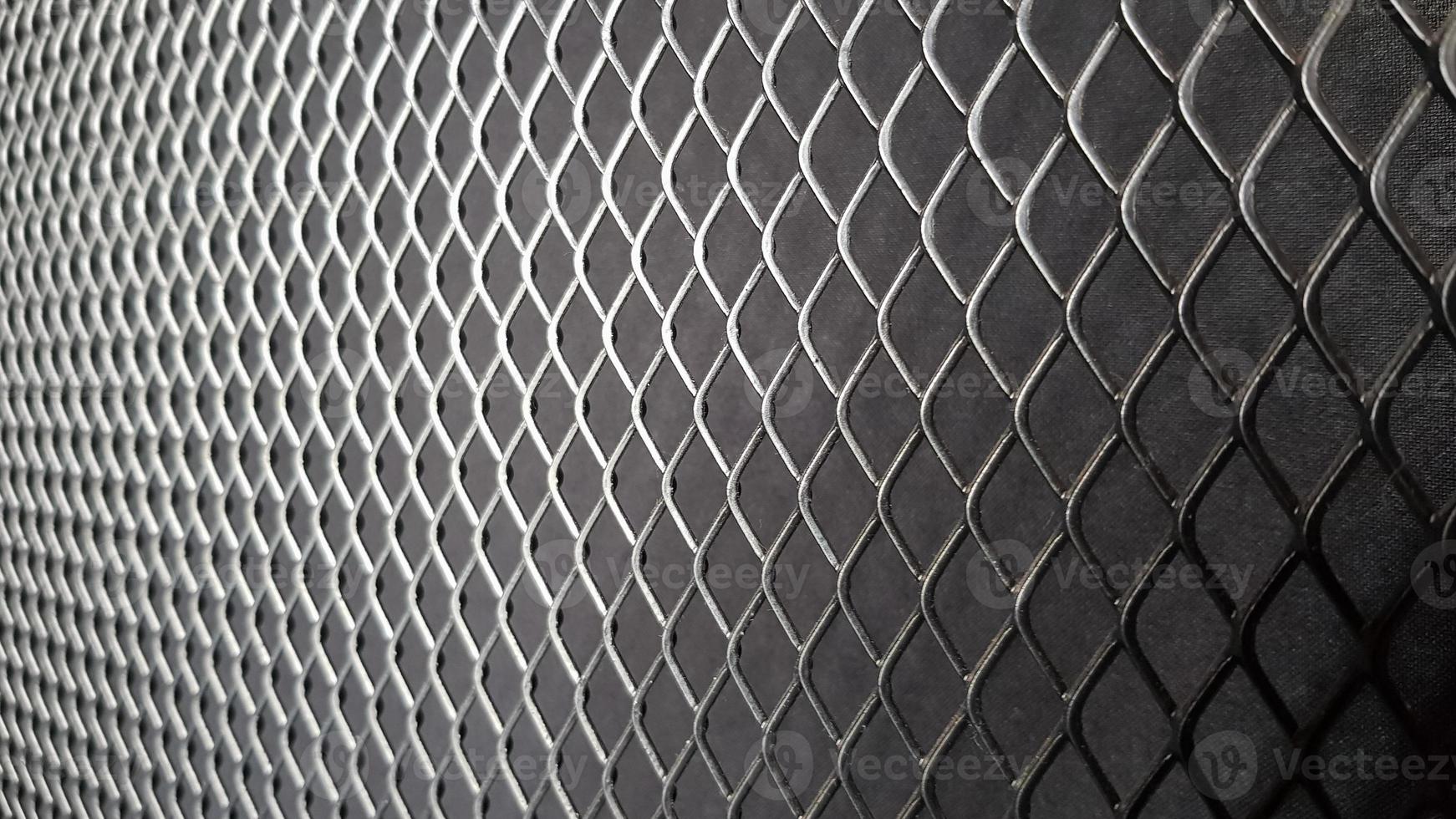 Metal mesh seamless pattern. Black metal mesh texture on a black background. Bulletin board for text and message design. Rhombus shape photo