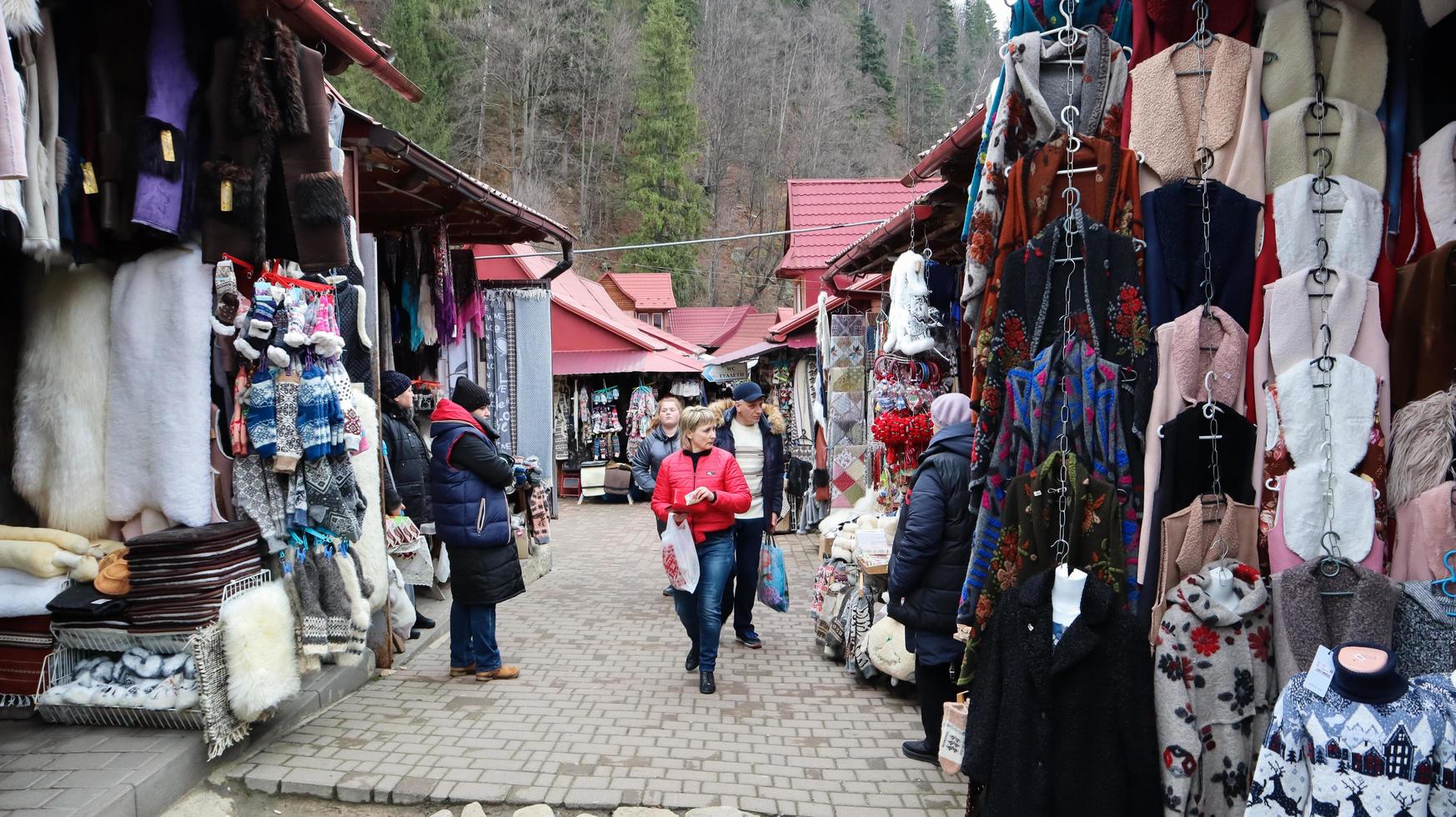 Souvenir market in Yaremche with traditional Carpathian handmade clothing, herbs and wooden tools. Ukrainian textiles, knitted socks, vests, hats. Ukraine, Yaremche - November 20, 2019 photo